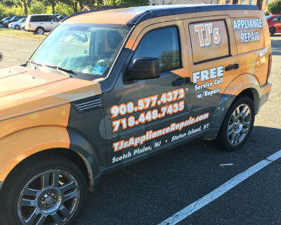 Van with an orange and black wrap on it. The side reads: TJ's Appliance Repair, FREE service call with repair!